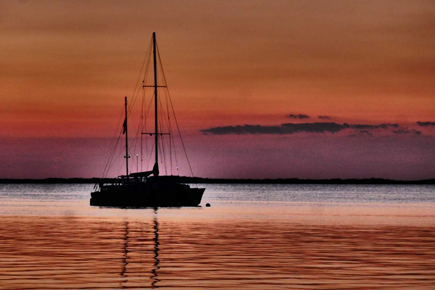 most romantic places to visit in the us - sailboat on water during colorful sunset